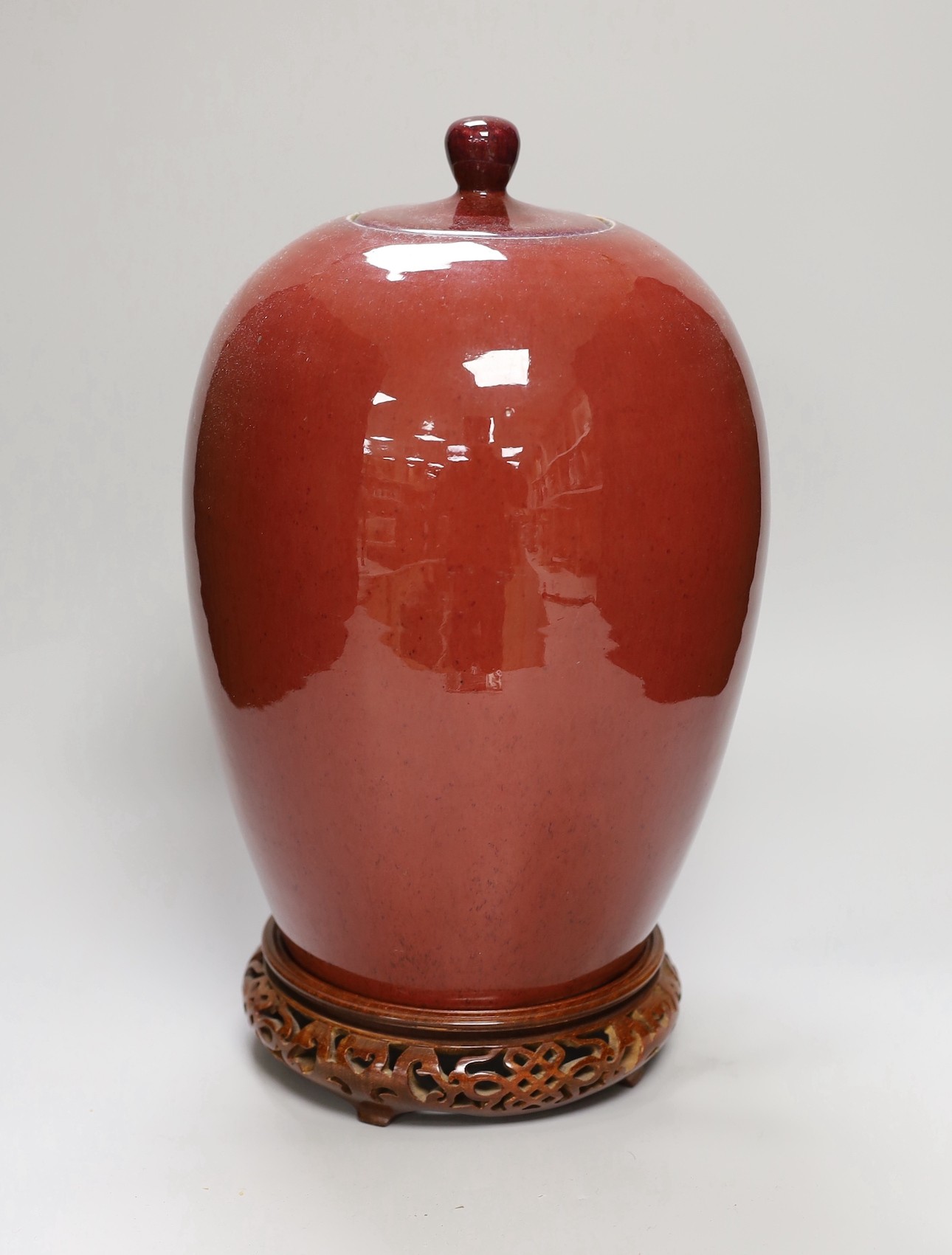 An early 20th century Chinese sang de boeuf jar and cover on hardwood stand, 36cm total